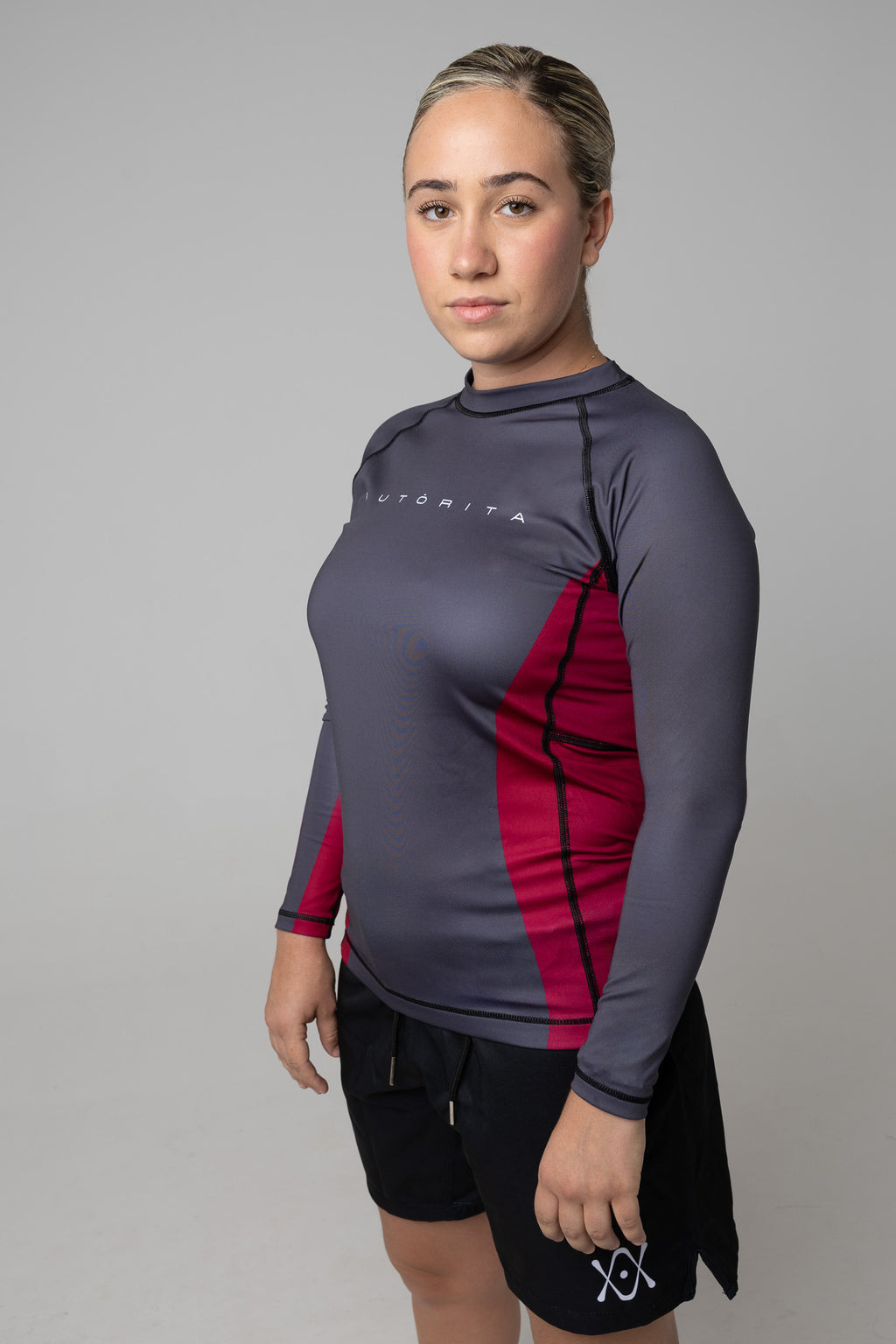 Mujer con longsleeve AUTORITA mostrando el panel lateral granate