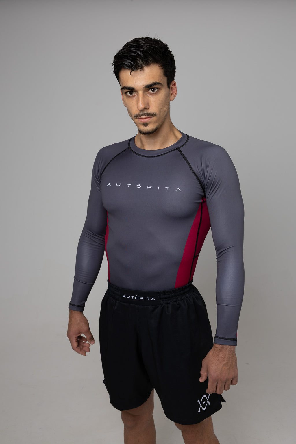 Hombre con rashguard gris de manga larga y paneles granates AUTORITA