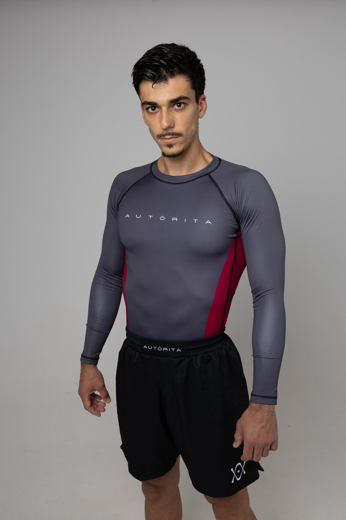 Hombre con rashguard gris de manga larga y paneles granates AUTORITA