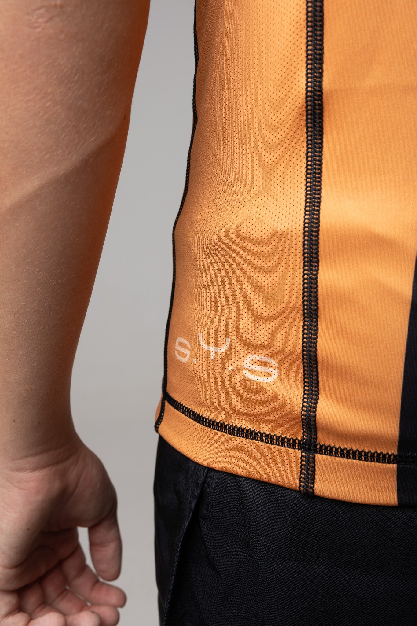 Detalle del panel lateral microperforado de rashguard naranja AUTŌRITA para Brazilian Jiu-Jitsu.