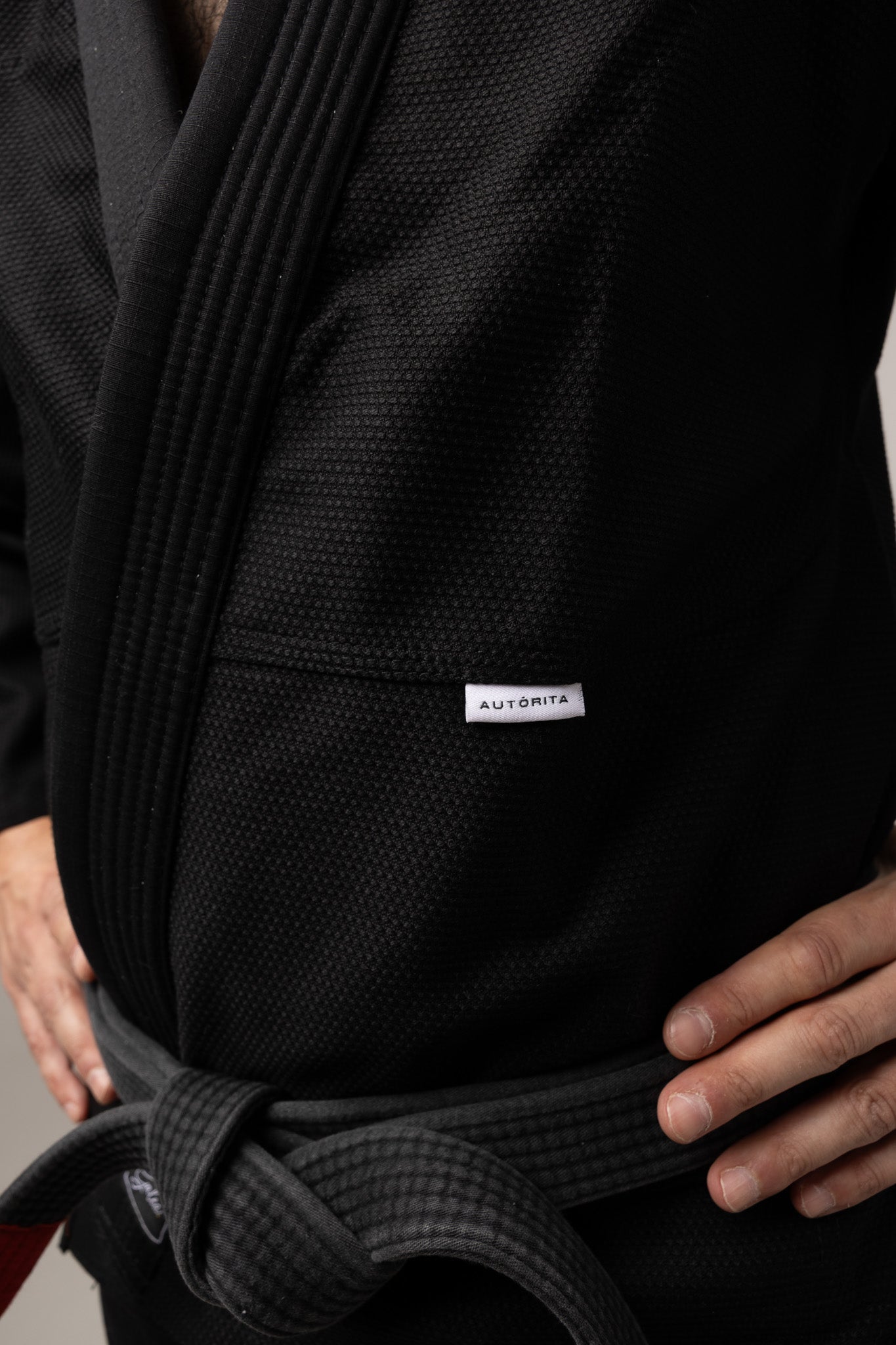 Detalle de la chaqueta del kimono BJJ negro AUTŌRITA Galea, tejido resistente y acabado premium