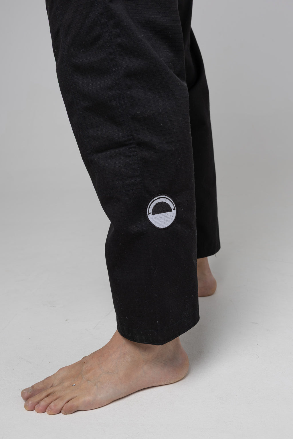 Parche circular en el pantalón del kimono BJJ negro AUTŌRITA Galea, detalle técnico y elegante