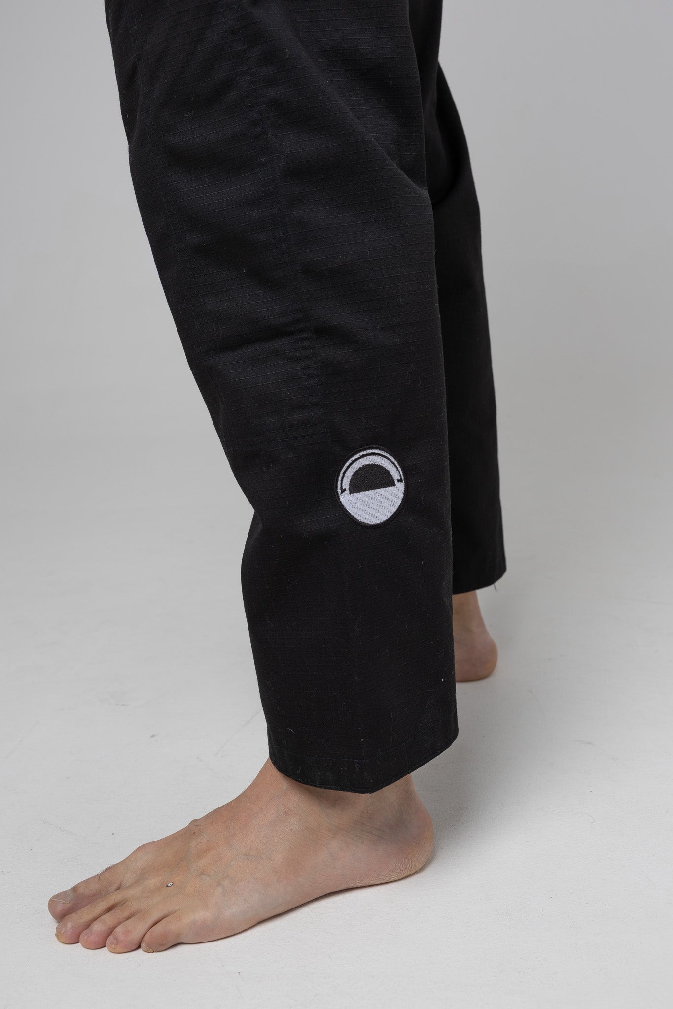 Parche circular en el pantalón del kimono BJJ negro AUTŌRITA Galea, detalle técnico y elegante