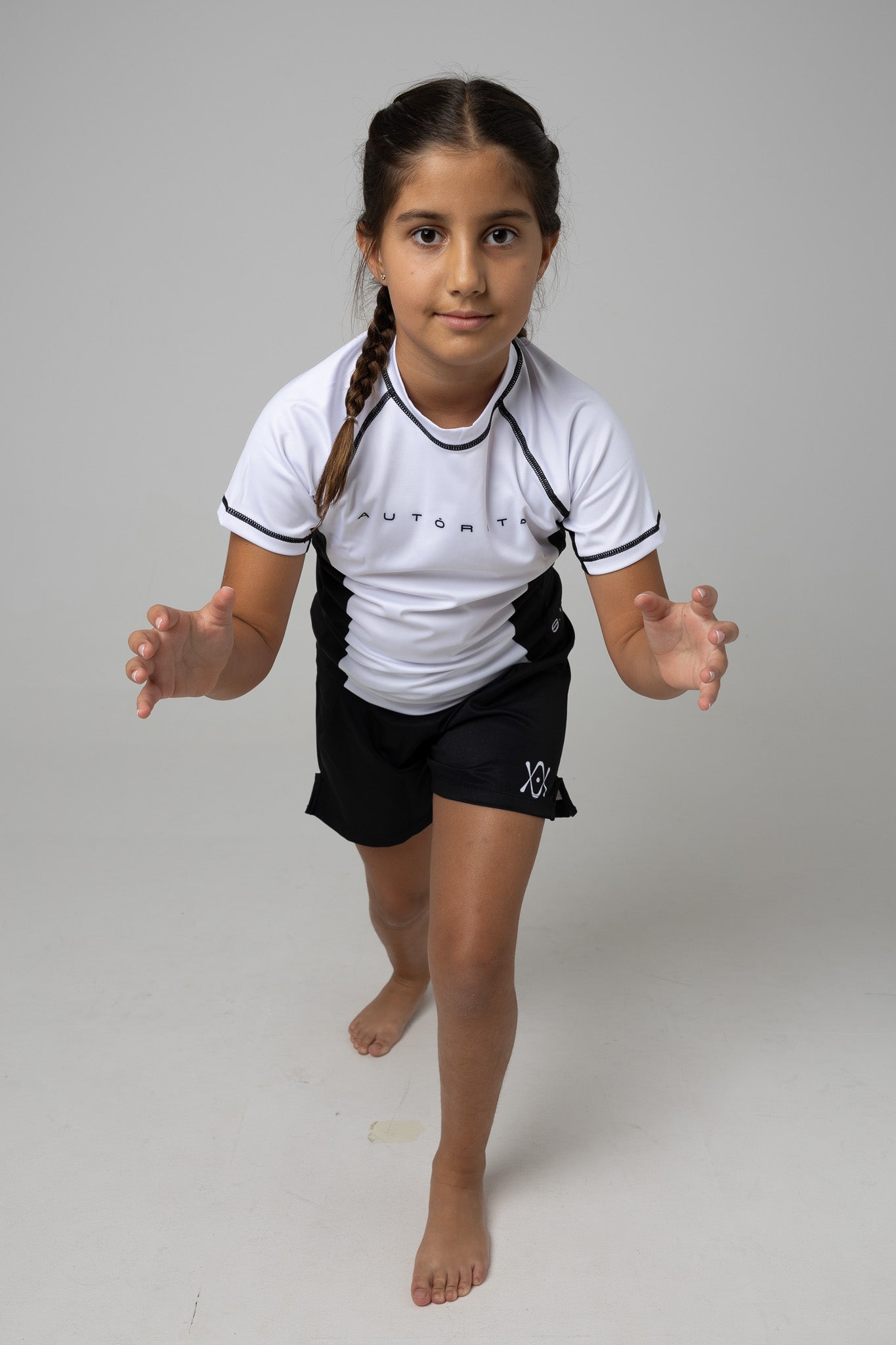 Licra de competición infantil AUTŌRITA en color blanco con detalles negros.