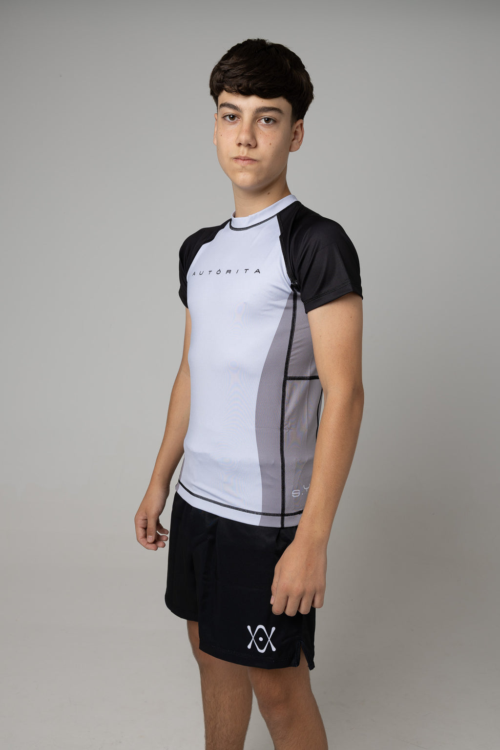 Modelo juvenil con licra gris y negra AUTŌRITA para Brazilian Jiu-Jitsu en estudio.