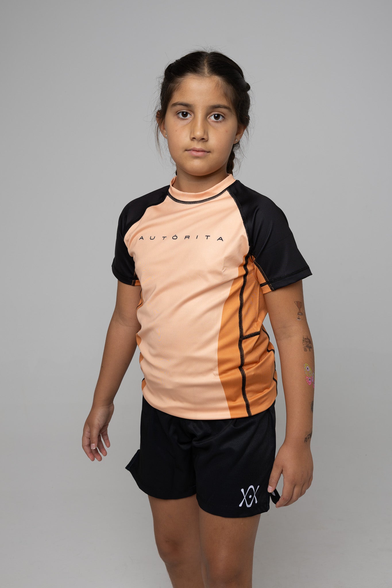 Licra naranja infantil AUTŌRITA para BJJ y grappling, diseño técnico con mangas negras.