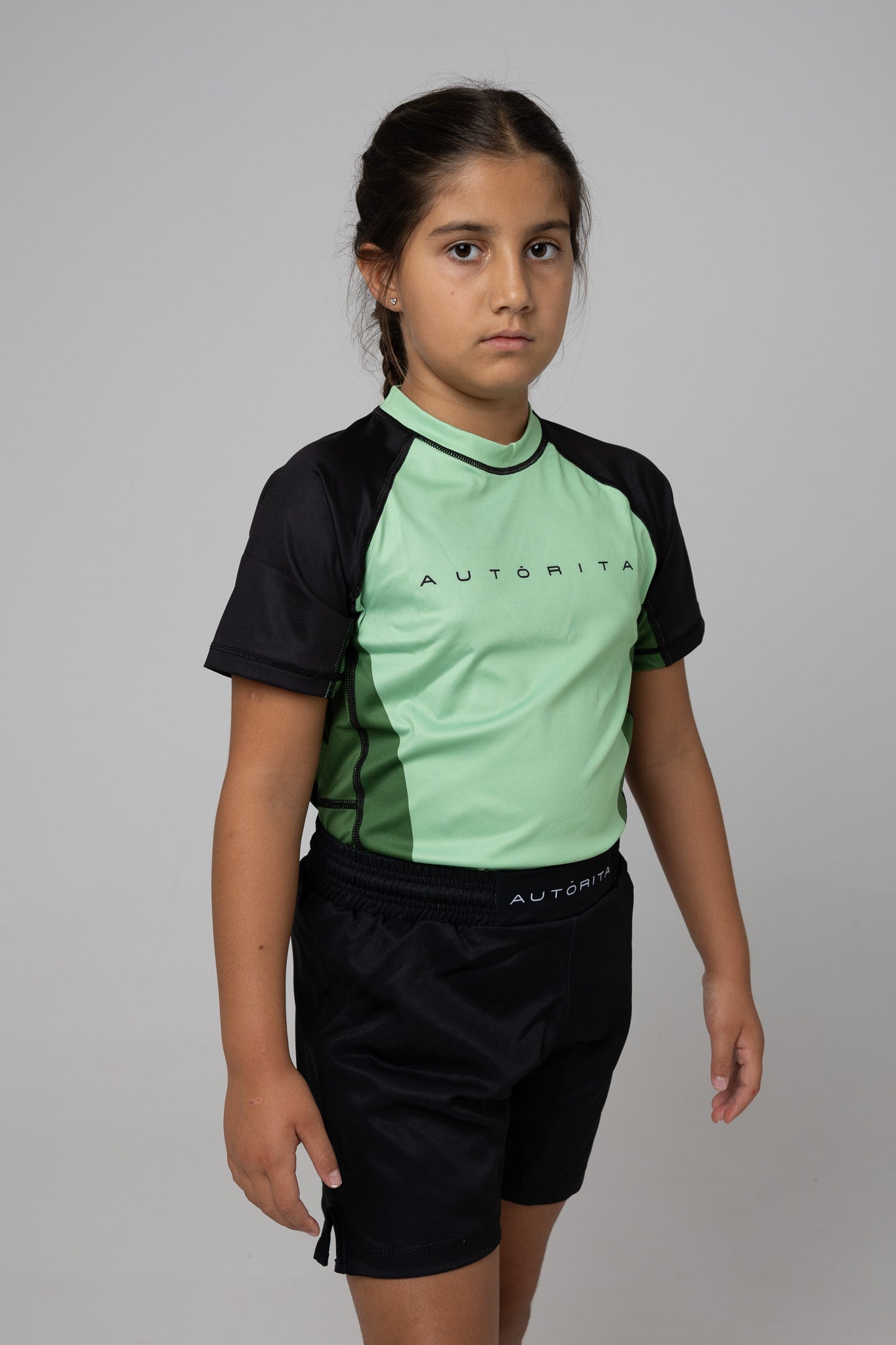 Licra verde infantil AUTŌRITA para BJJ y grappling, vista lateral con mangas negras.