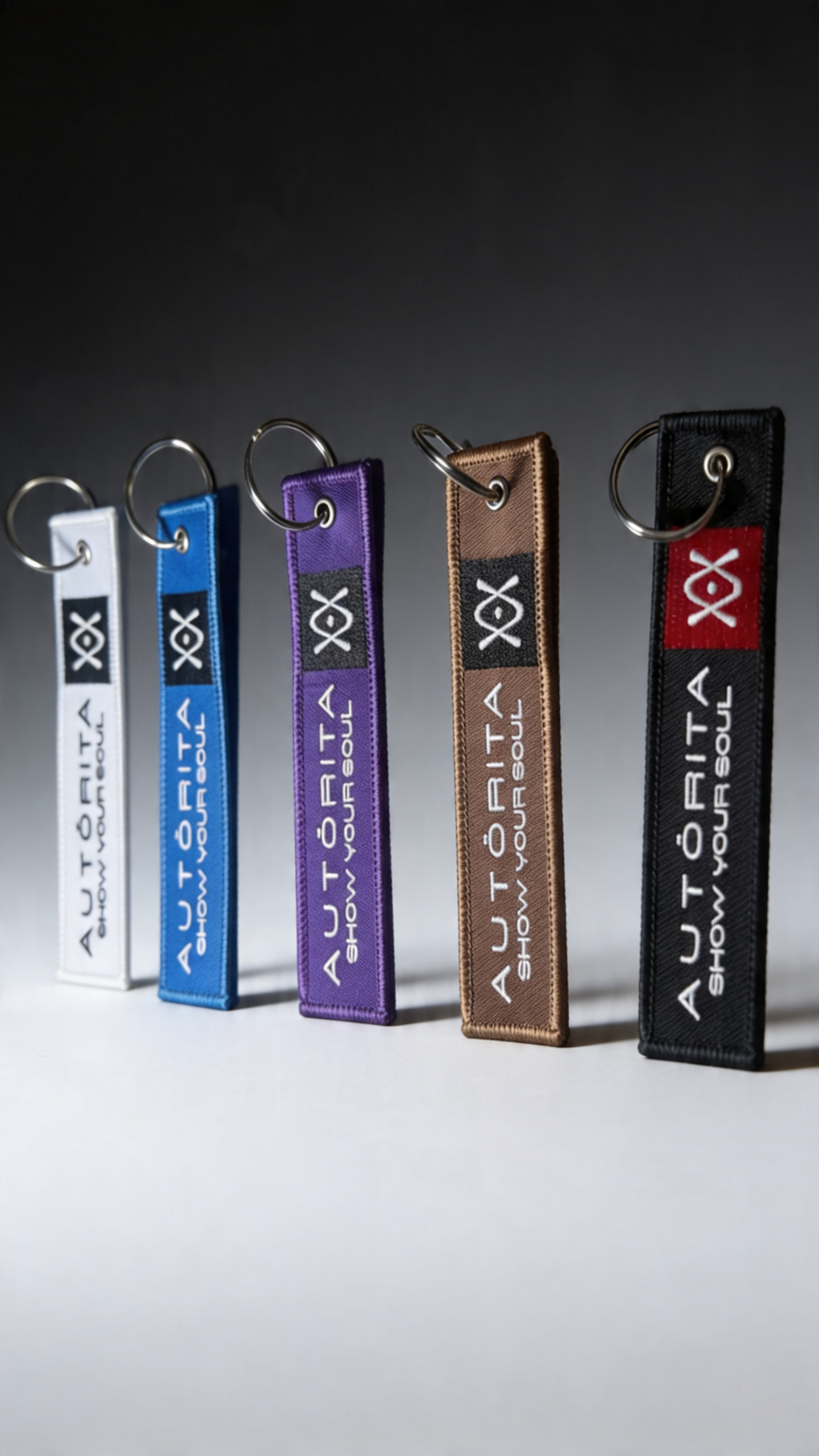 Colección de llaveros tejidos Autorita en colores de cinturón de Jiu-Jitsu Brasileño con logo bordado y argolla plateada