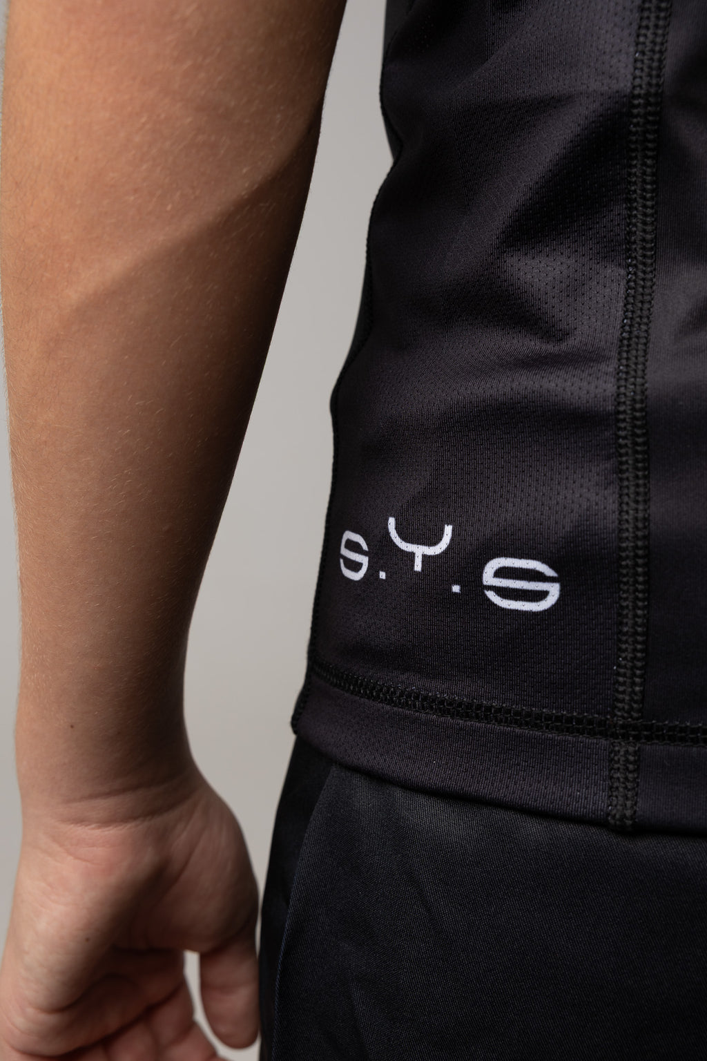 Detalle del panel lateral negro de la rashguard blanca AUTŌRITA para niños.